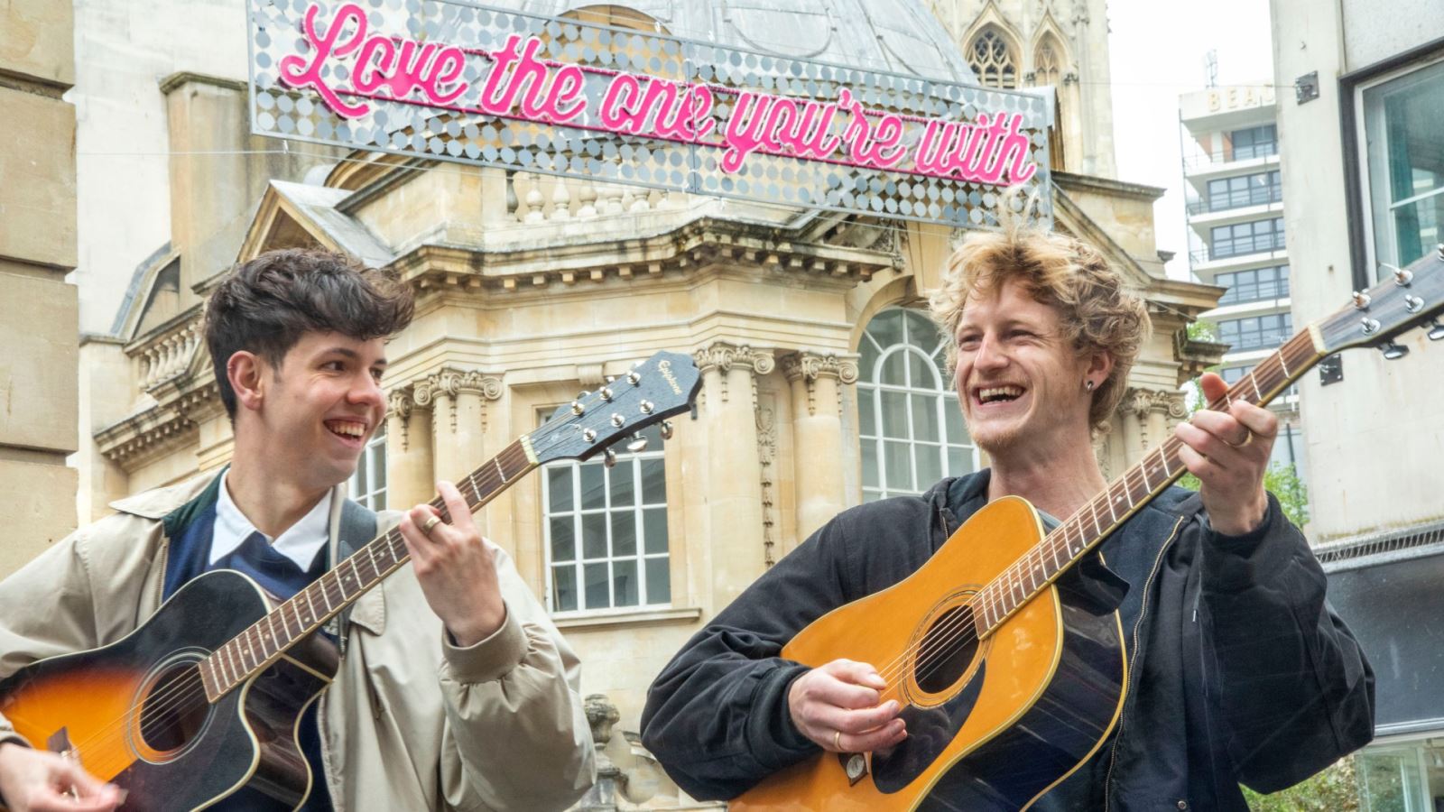 Buskers sing in front of the sign